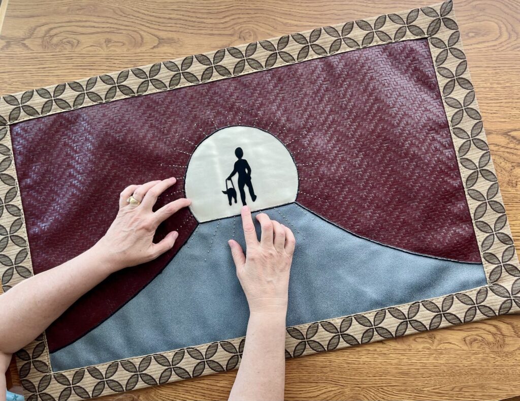 Picture of a silhouette or a person and pet going through a tunnel.