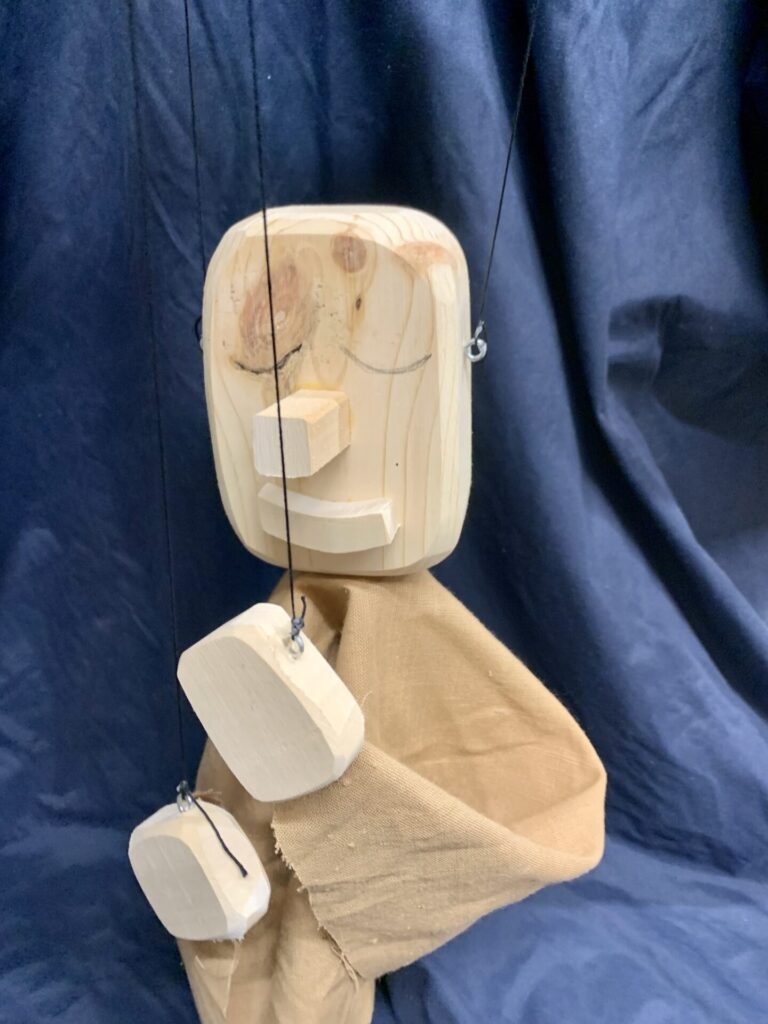 A wooden figure tied with strings