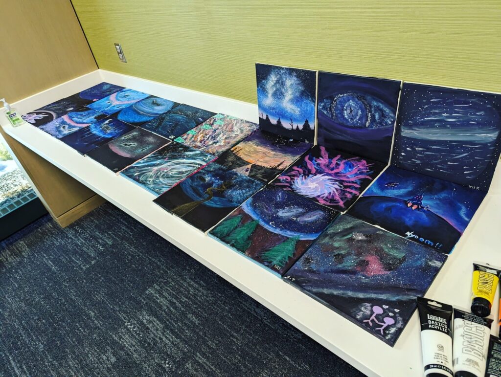 Paintings of celestial scenes displayed on a table. 