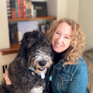 Karlyn Coleman smiling with a dog on her lap.