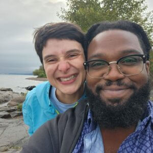Alsa on the left and Bruno on the right smiling on a beach.