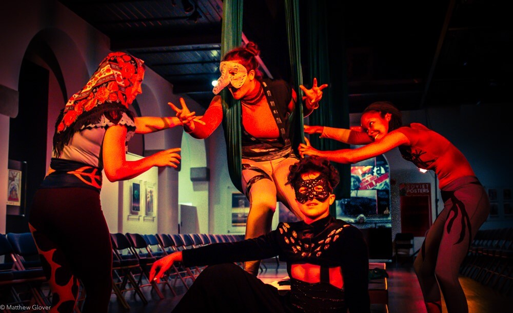 Characters in masks doing aerial work and performing a story. 