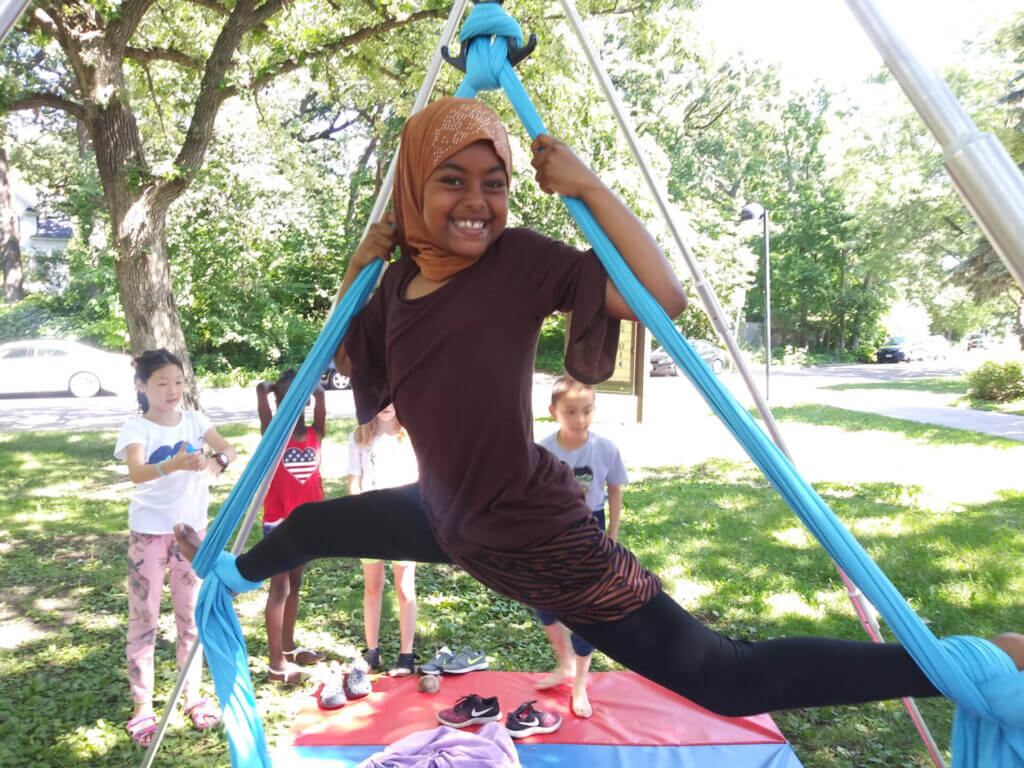 Student on a portable silk stand smiling. 