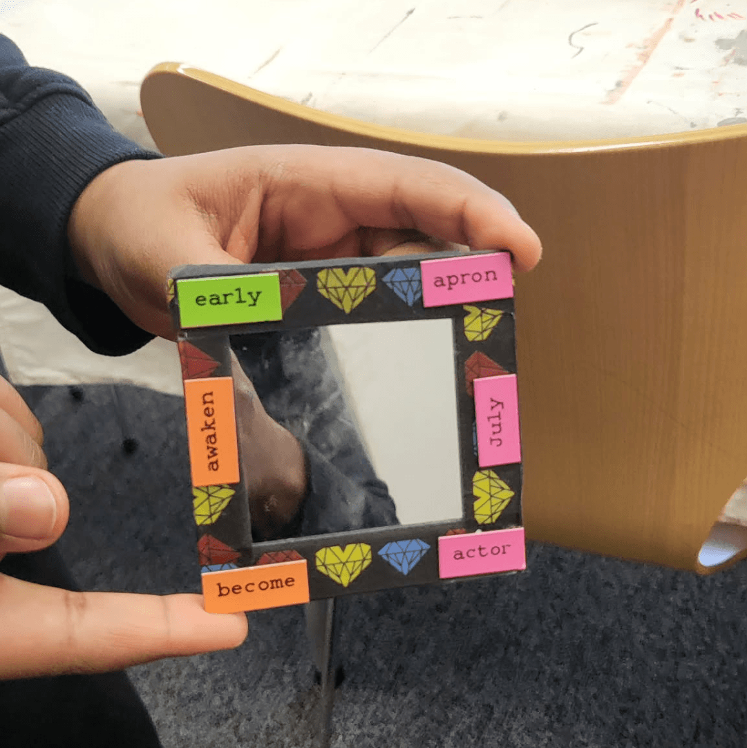 A student holding a mirror with their affirmations. 