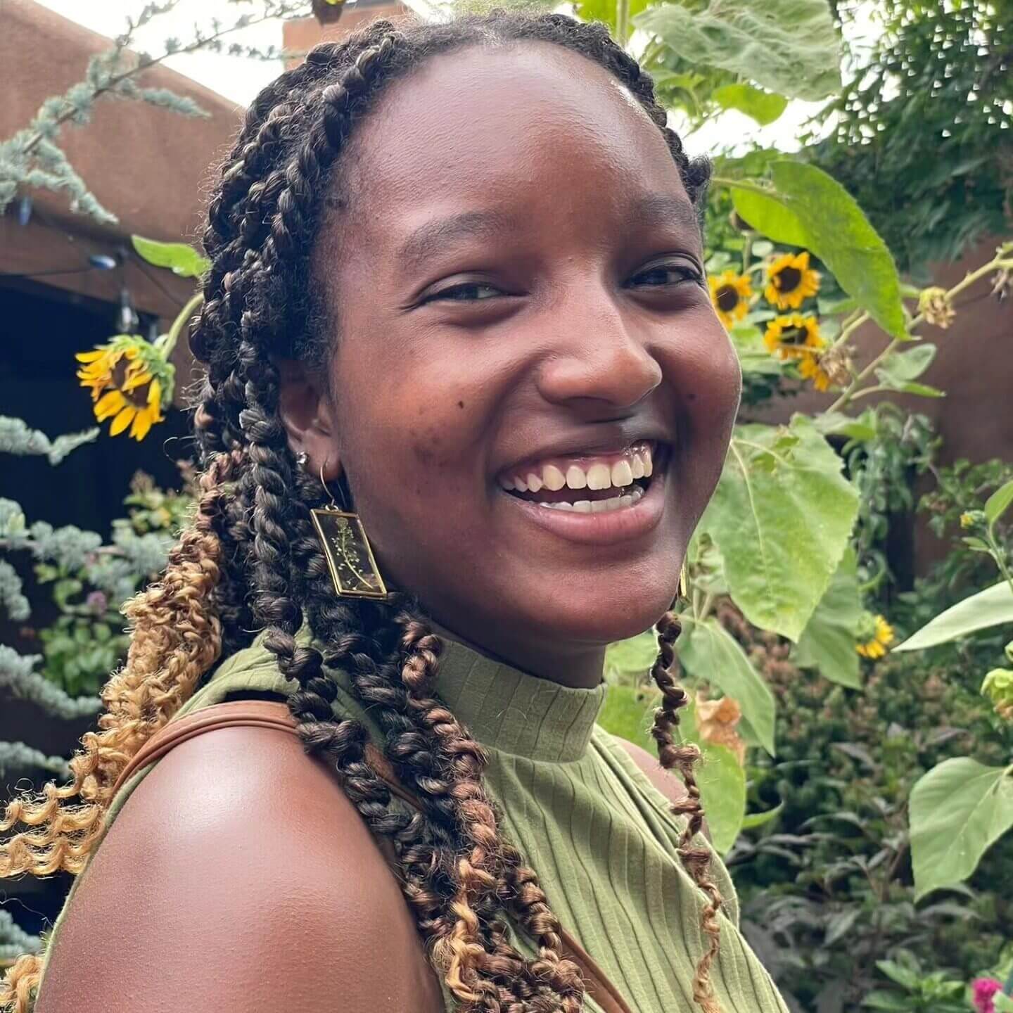 Smiling image of Shanel in front of flowers.