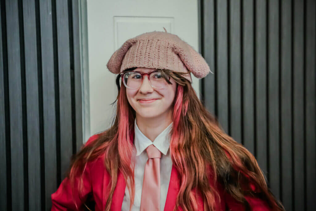 Student at the 2026 Youth Spoken Word Showcase wearing pink with pink hair.