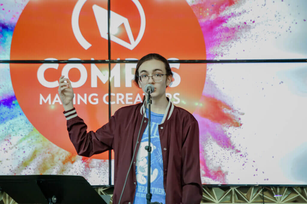 Jude performing with a gesture at the 2026 Youth Spoken Word Showcase.